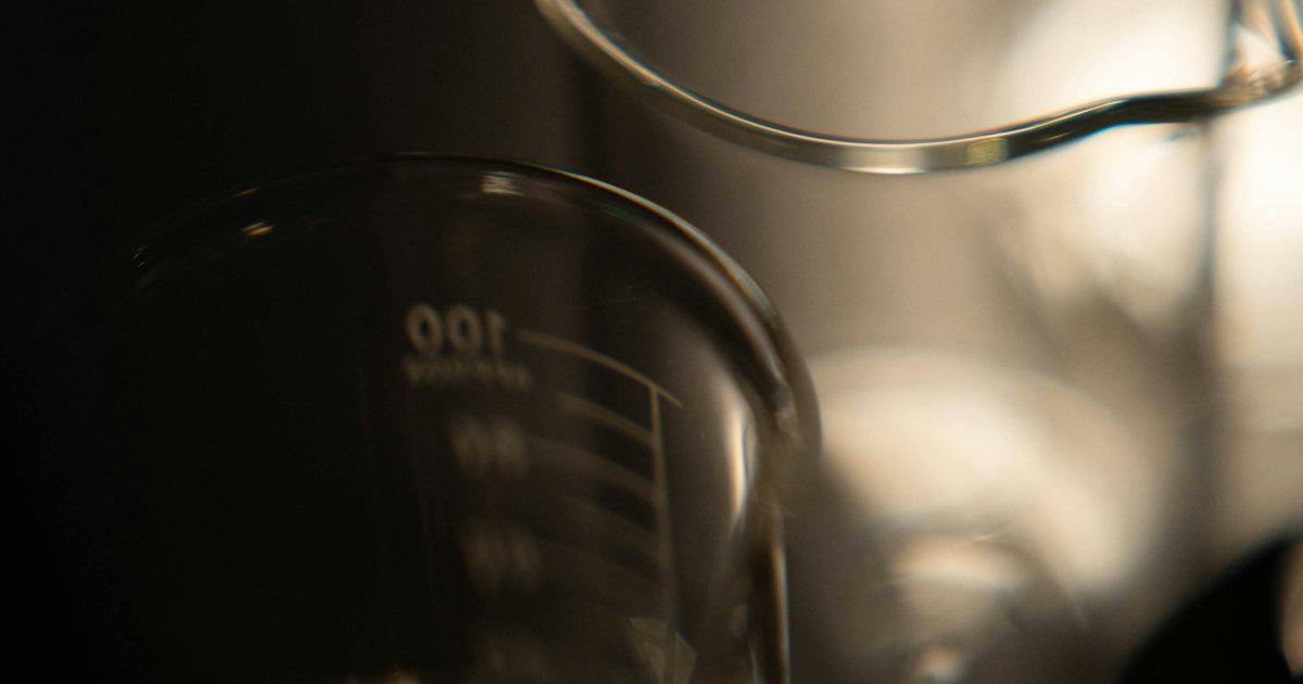 Glass laboratory beakers on a dark background