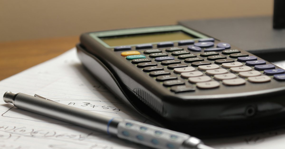 A calculator and a pen on a sheet of paper