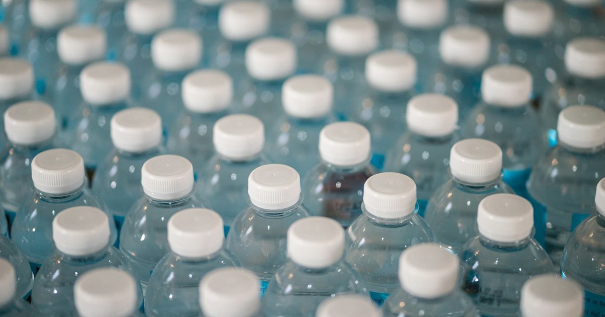 Rows of unlabelled plastic water bottles with white caps