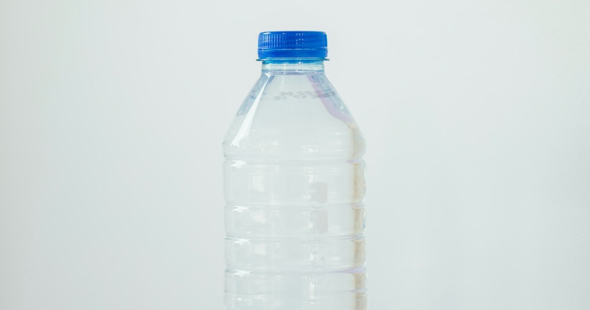 Unlabelled clear plastic water bottle with a blue cap